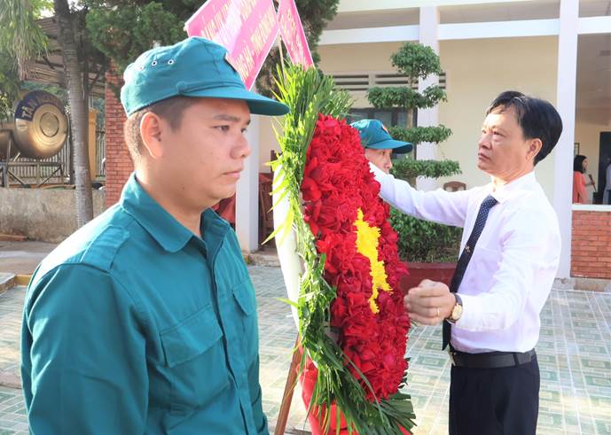 Bí thư Đảng ủy, Chủ tịch HĐND xã Long Hà Lê Anh Nam chỉnh trang lẵng hoa trước khi dâng hương.